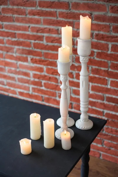 Veel oude witte kaarsen op oude zwarte tafel — Stockfoto