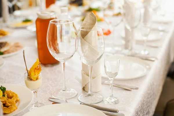 Mesa servida com diferentes alimentos e louças — Fotografia de Stock