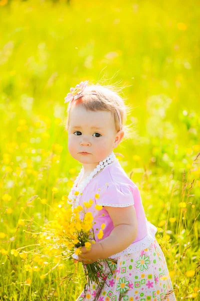 Niño pequeño jugando con flores de campo en el día de primavera o verano —  Fotos de Stock