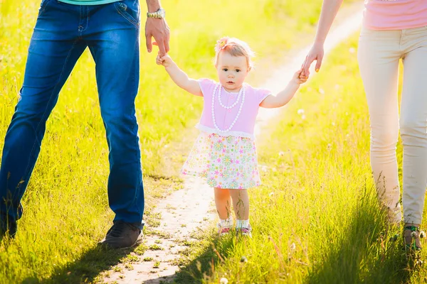 Kleine Tochter hält Hand in Hand mit Mama und Papa. Porträt des Glücklichen — Stockfoto