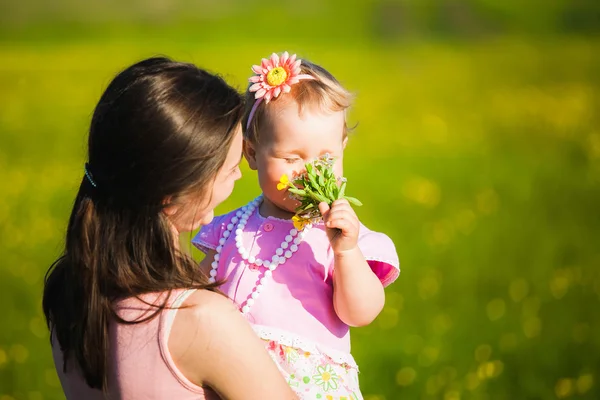 Kleines Mädchen, das Feldblumen riecht — Stockfoto