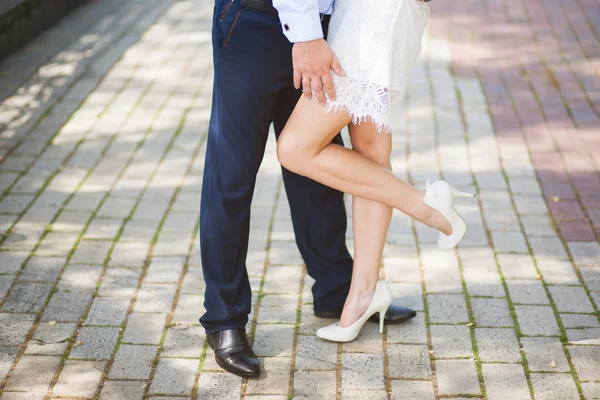 年轻的新婚夫妇的腿。新郎和新娘站在一起. — 图库照片