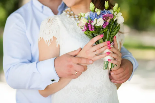 Весільний букет з квітів в руках красивих анонімних молодих — стокове фото