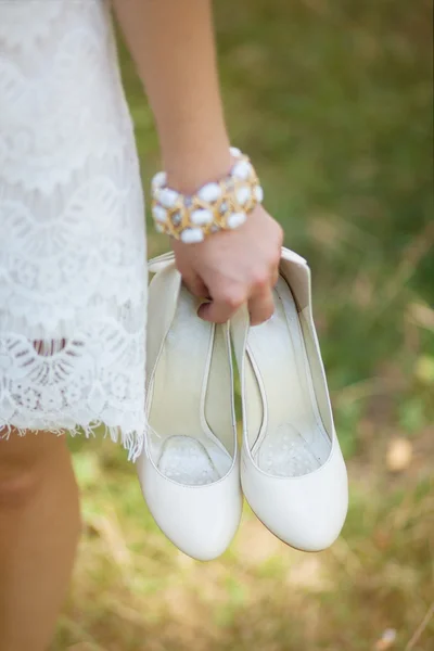 Ξυπόλυτος νεαρή κοπέλα φορώντας άσπρο όμορφο φόρεμα κρατώντας παπούτσια — Φωτογραφία Αρχείου