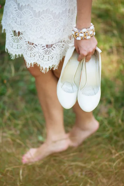 Barefoot young girl wearing white beautiful dress holding shoes — Stock Photo, Image