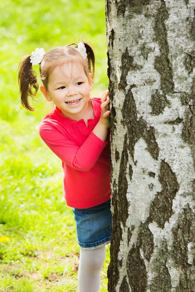 Bambino che gioca a nascondino all'aperto nel parco — Foto Stock
