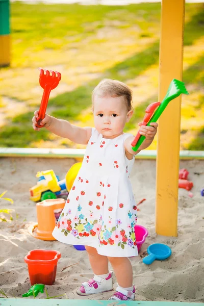 Bambino che gioca con i giocattoli nella sabbia sul parco giochi per bambini — Foto Stock