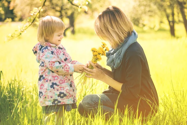 小さな女の子と若い母親は春を楽しむフィールド タンポポ flo — ストック写真