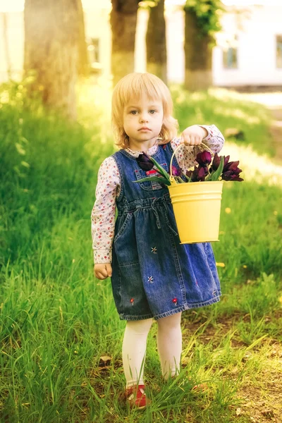Gyerek sárga kosár lila tulipán virágok tavasszal felülmúlni — Stock Fotó