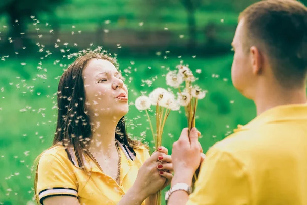 Pareja enamorada soplando alegres bolas de flores —  Fotos de Stock