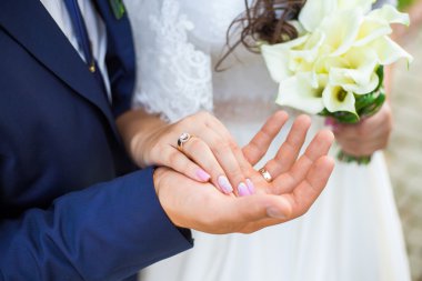 Düğün çifti el ele tutuşuyor.