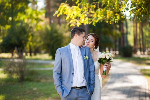 Счастливая невеста, жених стоит в зеленом парке — стоковое фото