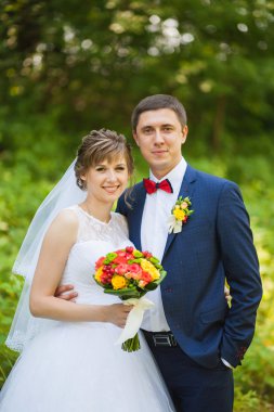 Mutlu gelin, öpüşme, gülüyor, gülüyor yeşil park, ayakta damat