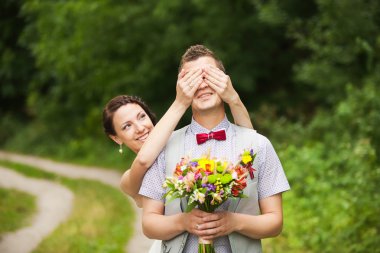 Happy bride, groom standing in green park clipart