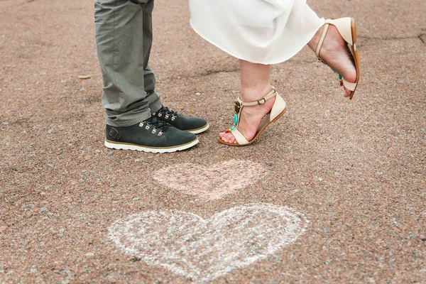 Símbolos del corazón con crayones en el suelo y dos personas enamoradas — Foto de Stock