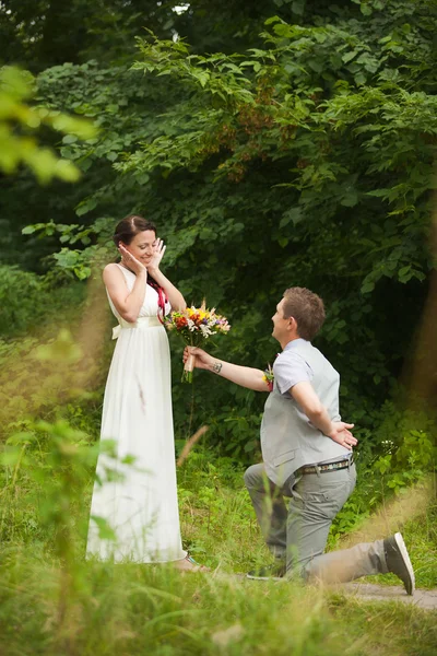 Happy bride, groom standing in green park — Stock Photo, Image