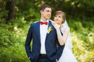 Mutlu gelin, öpüşme, gülüyor, gülüyor yeşil park, ayakta damat