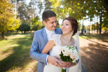 Mutlu gelin, öpüşme, gülüyor, gülüyor yeşil park, ayakta damat
