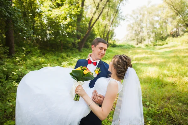 Noiva feliz, noivo em pé no parque verde, beijando, sorrindo, rindo — Fotografia de Stock