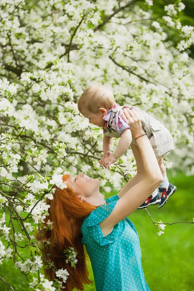 Porträt einer glücklichen Mutter und ihres Sohnes im Frühlingsgarten — Stockfoto