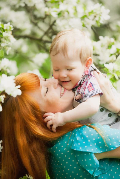 Porträt einer glücklichen Mutter und ihres Sohnes im Frühlingsgarten — Stockfoto