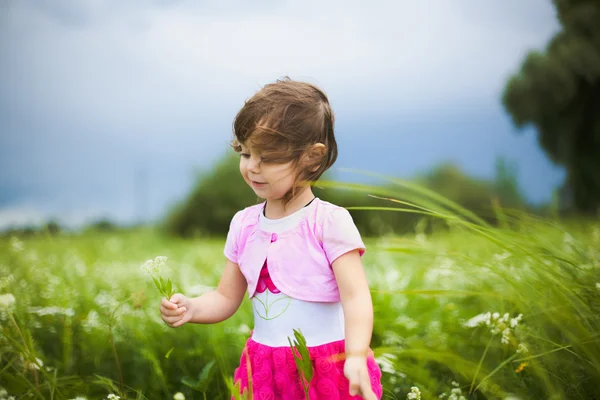Beautiful carefree girl playing outdoors in field — Stock Photo, Image