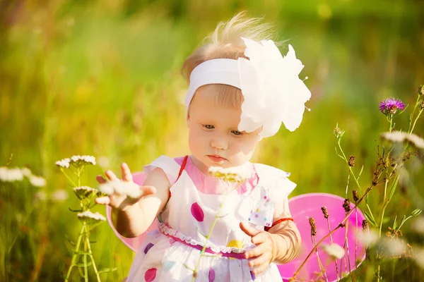 Beautiful carefree girl playing outdoors in field with high gree — Stock Photo, Image