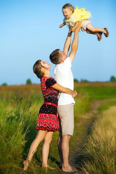 Счастливая семья, весело проводящая время на свежем воздухе летом — стоковое фото