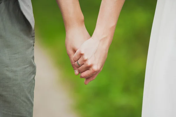 Мужчина и женщина держатся за руки. молодая влюбленная пара, стоя на ногах — стоковое фото