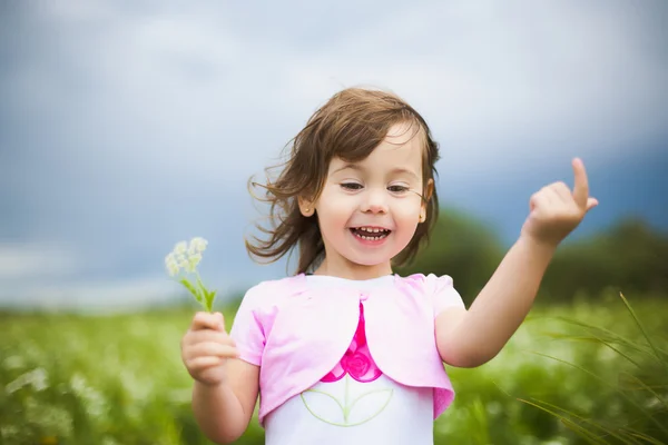 Beautiful carefree girl playing outdoors in field — Zdjęcie stockowe