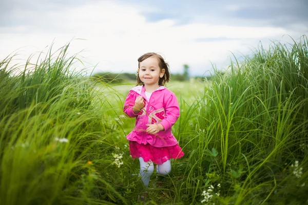 Красивая девочка, играющая на открытом воздухе в поле — стоковое фото