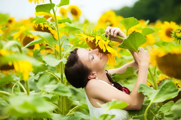 Feliz pareja enamorada divirtiéndose en el campo lleno de girasoles — Foto de Stock