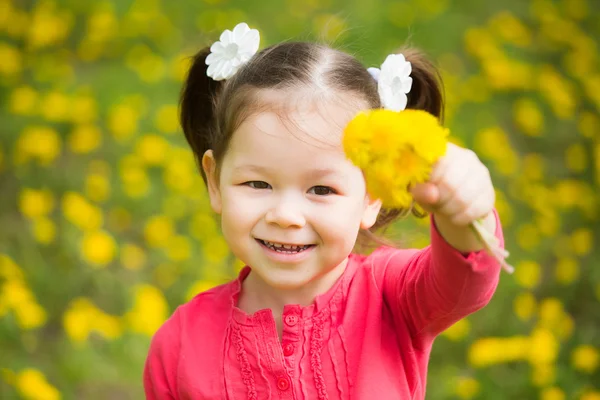 Мила красива маленька дівчинка з жовтими кульбабами — стокове фото