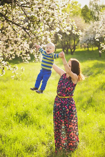 Baby auf Händen der Mutter. Frau spielt mit Kind draußen — Stockfoto