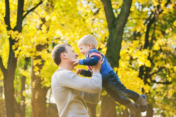 Glückliche zweiköpfige Familie, die im Herbstwald lacht und spielt — Stockfoto