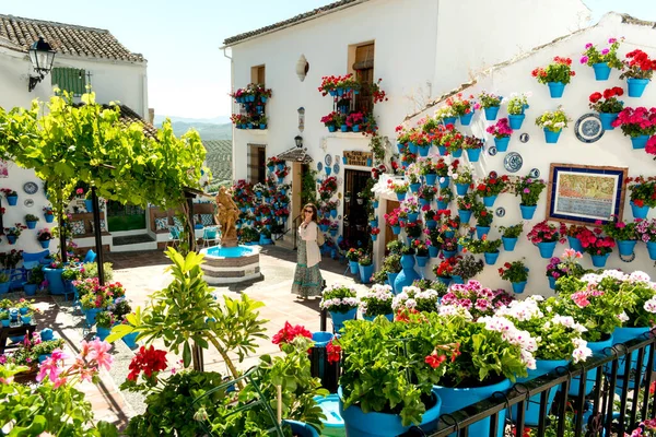 Schöne Frau mitten im andalusischen Innenhof voller Farben und Blumen — Stockfoto