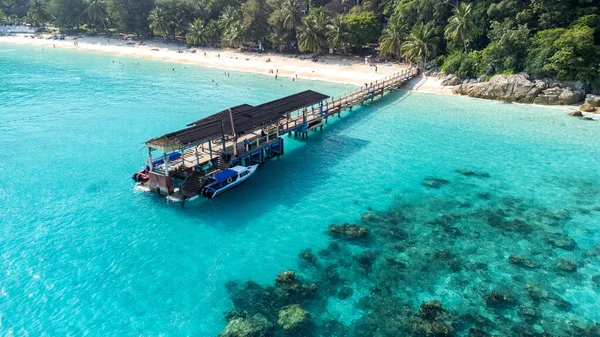 Turkuaz suların yüksek açılı görüntüsü, beyaz kumlu plaj, ve Malezya 'daki Perhentian Adaları' nda bir iskele. Seyahat acenteleri, yaz tatili promosyonları ve tropikal hedef pazarlama için ideal. Yüksek kalite fotoğraf