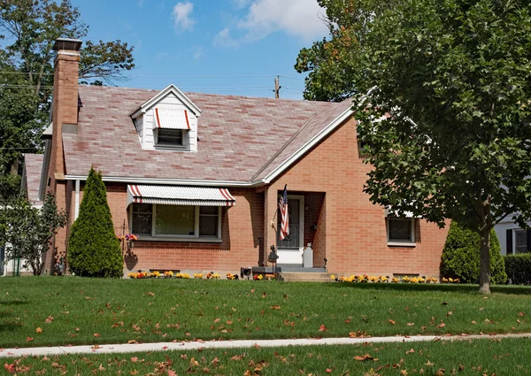 Yapay çiçek ile küçük tuğla ev