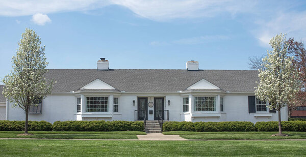 White Identical Duplex in Spring with Flowering Pear Trees