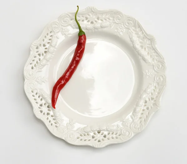 Röd paprika på vit platta — Stockfoto