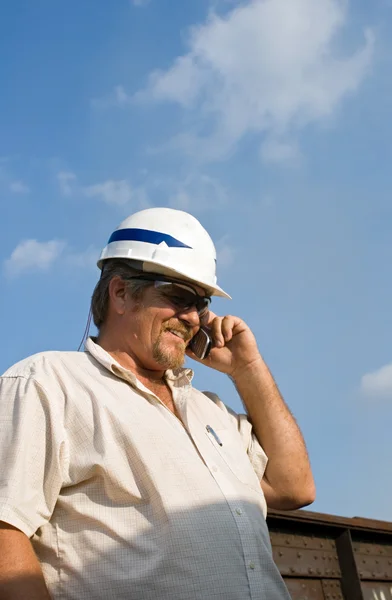 Werknemer met harde hoed op telefoon — Stockfoto