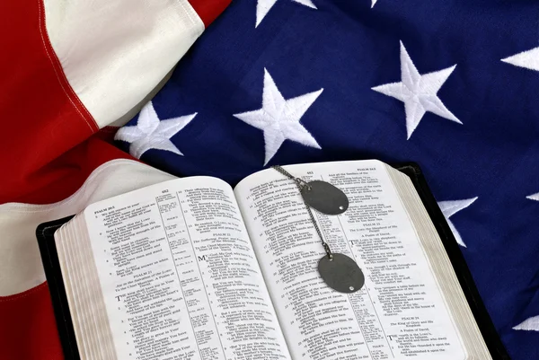 Offene Bibel mit Hundeanhängern auf amerikanischer Flagge — Stockfoto