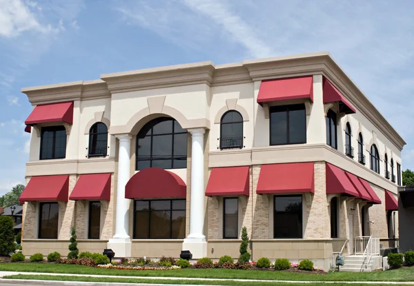 Tan Building with Red Awnings Royalty Free Stock Photos