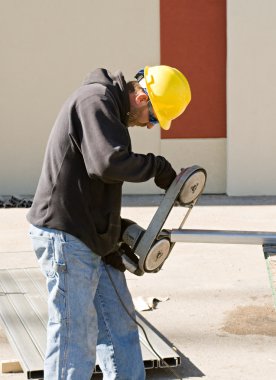 Worker Using Porta-Band Saw clipart