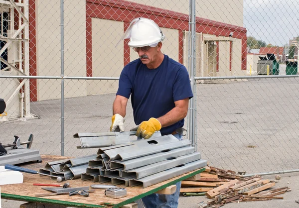 Trabalhador empilhamento de parafusos metálicos — Fotografia de Stock