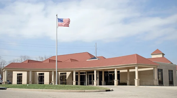 Здание на красной крыше с флагом — стоковое фото