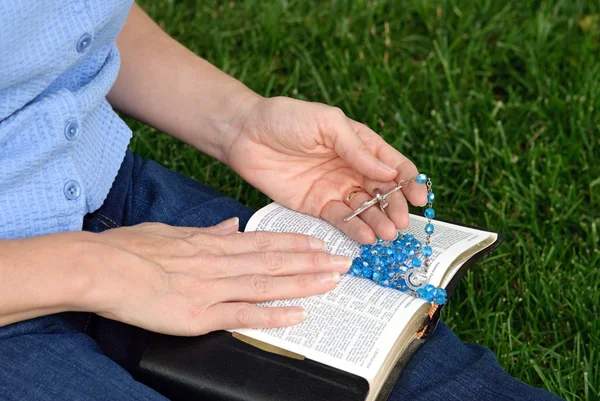 Handen met rozenkrans op Bijbel — Stockfoto
