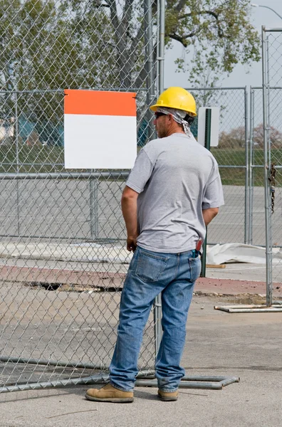 Trabalhador olhando para o sinal em branco — Fotografia de Stock