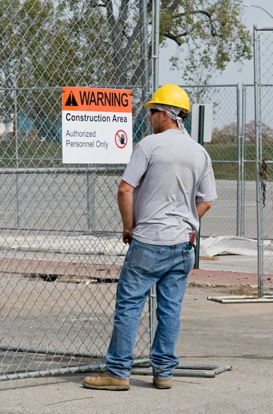 Arbeiter liest Warnschild — Stockfoto