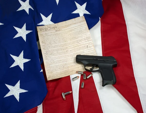 Constitución con pistola de mano y cartuchos en la bandera americana — Foto de Stock